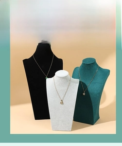 Close-up of velvet bust necklace display stands in black, white, and dark green colors