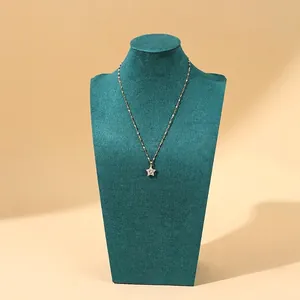 Elegant gold star pendant necklace with zircon stone on a green velvet neck display stand