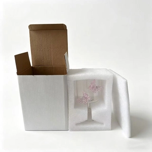 Detail view of champagne glass with pink butterfly and secure foam protective packaging