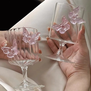 Elegant champagne glass with pink glass butterfly detail and striped texture design