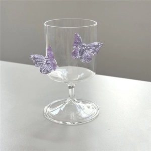 Close-up of elegant champagne glass featuring purple 3D butterfly glass accents