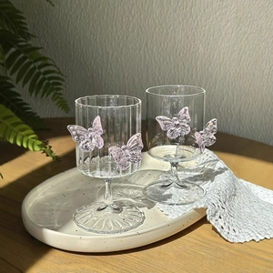 Detail of high borosilicate champagne glasses with pink 3D butterfly ornaments