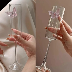 Elegant champagne glass with a pink glass butterfly on a tall slender stem