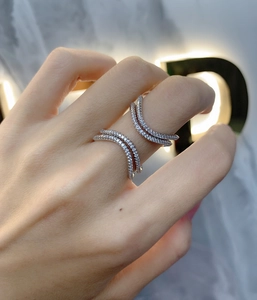 Detailed view of silver double-row V-shaped ring with pave-set zircon on model hand