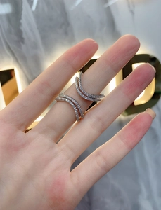 Detail of silver double V-shaped open ring with pavé micro-inlaid white zirconias on finger