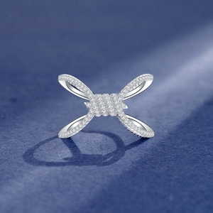Sparkling knot ring in silver finish with white micro-pave stones on blue background