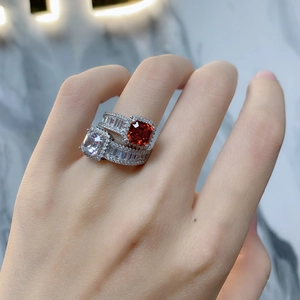 Macro shot of stacked 925 silver rings featuring red cushion-cut gem and white zircon