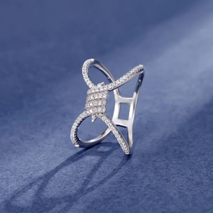 Silver rope knot cross ring with micro-pave white zircon crystals on dark blue background