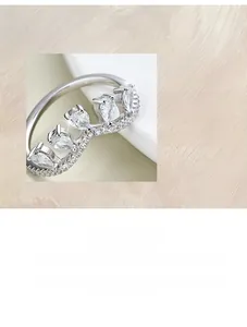 Detailed view of S925 silver V-shaped ring with pear-cut zircon on white geometric stand