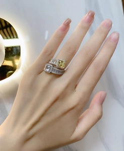 Close-up of stacked 925 silver rings with yellow and white cushion cut gemstones