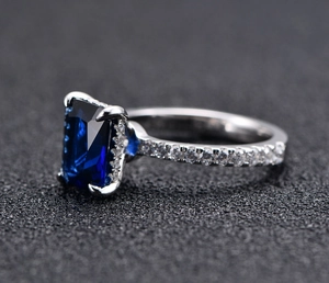 Macro side view of 925 silver ring featuring 7x9mm emerald-cut blue sapphire gemstone