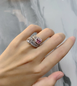 Close-up of stacked 925 silver rings with pink and clear Asscher cut synthetic gemstones
