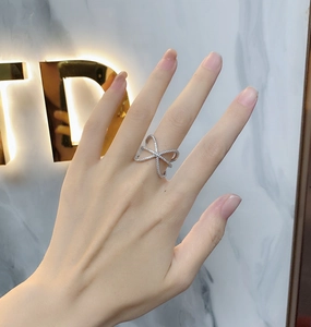 Macro shot of 925 silver X-shaped criss-cross ring with white sparkling pave crystals