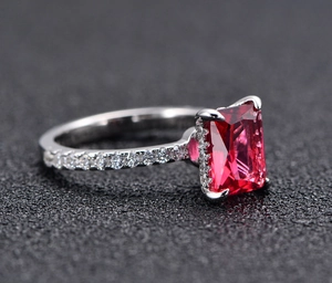 Macro side view of rectangular red emerald cut gemstone with 925 silver pave setting