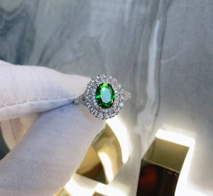 Vue détaillée de bague émeraude ovale avec double halo de diamants sur monture argent