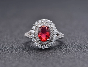 Vue macro de bague ovale en pierre rouge avec double halo et anneau en argent S925