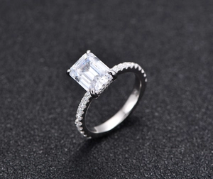 Macro shot of 925 silver ring featuring emerald-cut stone with four-prong pave setting
