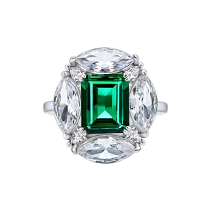 Emerald-cut green gemstone ring with white marquise and pear accents in silver finish