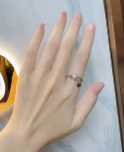 Close-up of 925 sterling silver ring with micro-paved crystal ball and small fish pendant