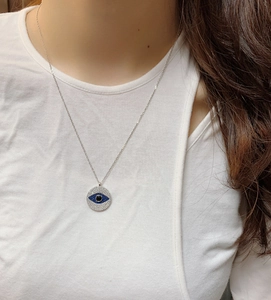 Close-up of S925 sterling silver evil eye necklace with blue zircons on model neck