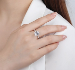 Macro detail of emerald-cut gemstone ring with micro-pave diamonds on silver band