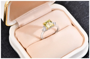 Macro shot of square yellow gemstone ring in silver band with luxury jewelry gift box