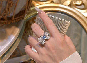 Detailed view of silver butterfly ring with light blue square stone and pave diamonds