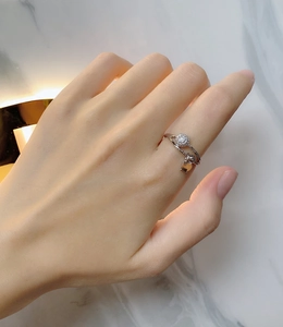 Detail of 925 sterling silver crisscross ring featuring zircon stone and heart charm