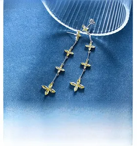Detail of silver drop earrings with yellow marquise gems on blue velvet background