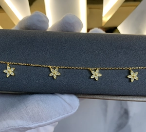 Détail du bracelet trèfle doré avec bordure milgrain et incrustation de zircon