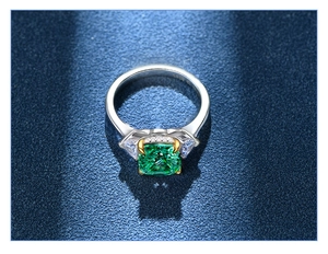 Macro shot of 925 silver ring with square green gemstone and gold claw details