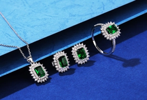 Detailed set of S925 silver jewelry with emerald green stones and diamond halo