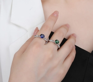 Detail of twisted leaf silver rings with round blue and green gems and micro diamonds