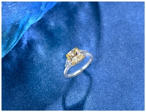 Macro view of cushion cut yellow synthetic gemstone ring with triangular side stones