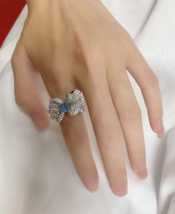 Close-up of butterfly wing ring with blue square gemstone worn on finger in detail