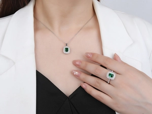 Detail of S925 silver jewelry set featuring emerald cut green stones and halo setting