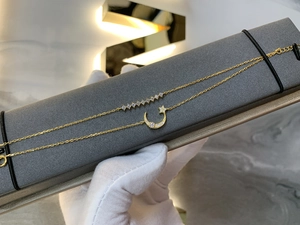 Macro detail of gold star and moon pendant necklace with delicate zircon inlays on display