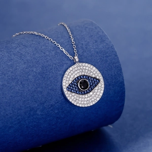 Elegant S925 sterling silver Evil Eye necklace with blue crystals on a blue display stand