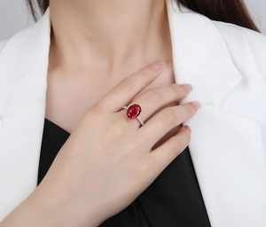 Detail of 925 sterling silver ring featuring a large oval red gemstone on a finger
