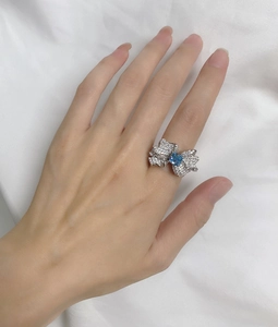 Macro shot of 925 sterling silver butterfly ring with square blue gemstone and pavé stones