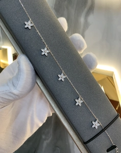 Gros plan du bracelet trèfle en argent 925 avec breloques fleurs et oxydes de zirconium