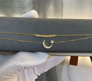 Detailed macro view of gold plated star and moon bracelet with shimmering zircons