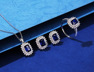 Detailed set showing rectangular blue emerald-cut sapphire pendant, earrings and ring set