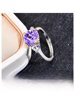 Detail of square purple gemstone ring with triangle side stones in silver band