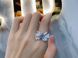 Detailed view of sterling silver butterfly ring with blue square carbon diamond on hand