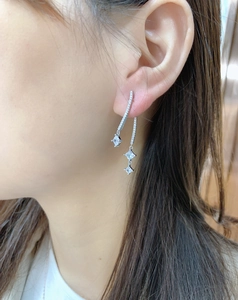 Macro shot of 925 sterling silver drop earrings with cubic zirconia on model ear