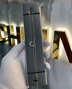 Detail of gold star and moon layered bracelet featuring adjustable chain and clasp