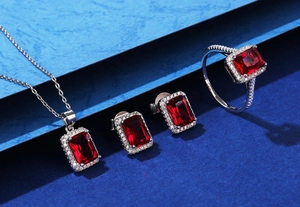 Detailansicht eines Schmucksets mit smaragdgeschliffenen roten Edelsteinen und Silber
