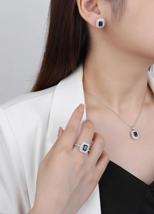 Detail of S925 sterling silver jewelry set featuring emerald cut blue gemstones and halos
