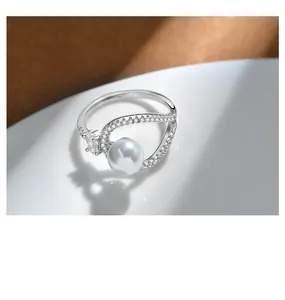 Macro shot of a 925 sterling silver pearl ring with sparkling pavé cubic zirconia